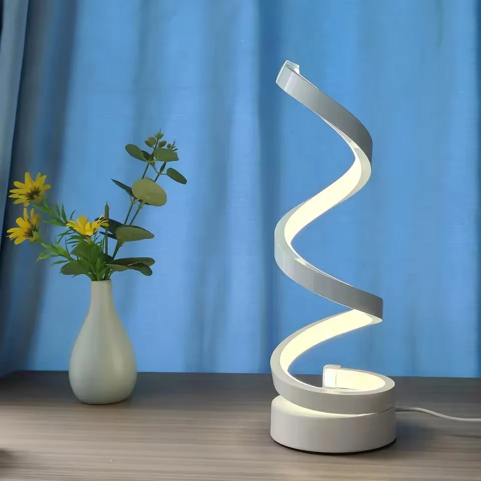 A modern, elegant white spiral desktop lamp, powered by USB with three-color dimming, suitable for various types of rooms.