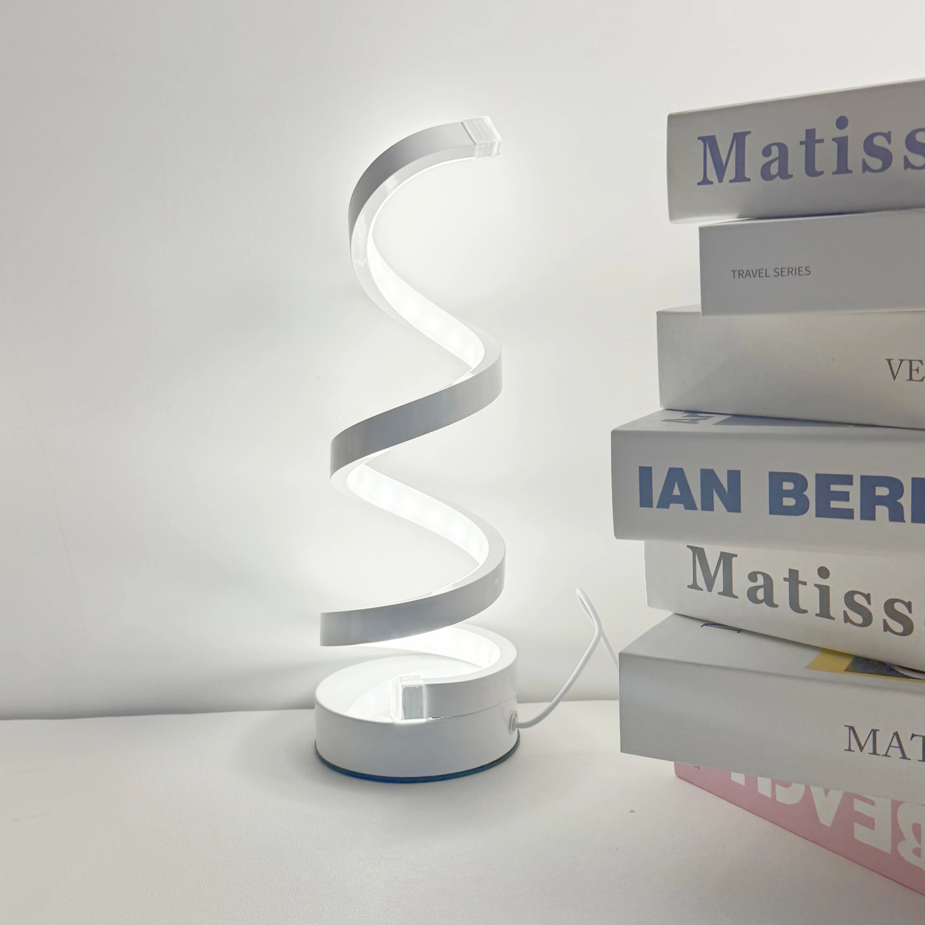 A modern, elegant white spiral desktop lamp, powered by USB with three-color dimming, suitable for various types of rooms.