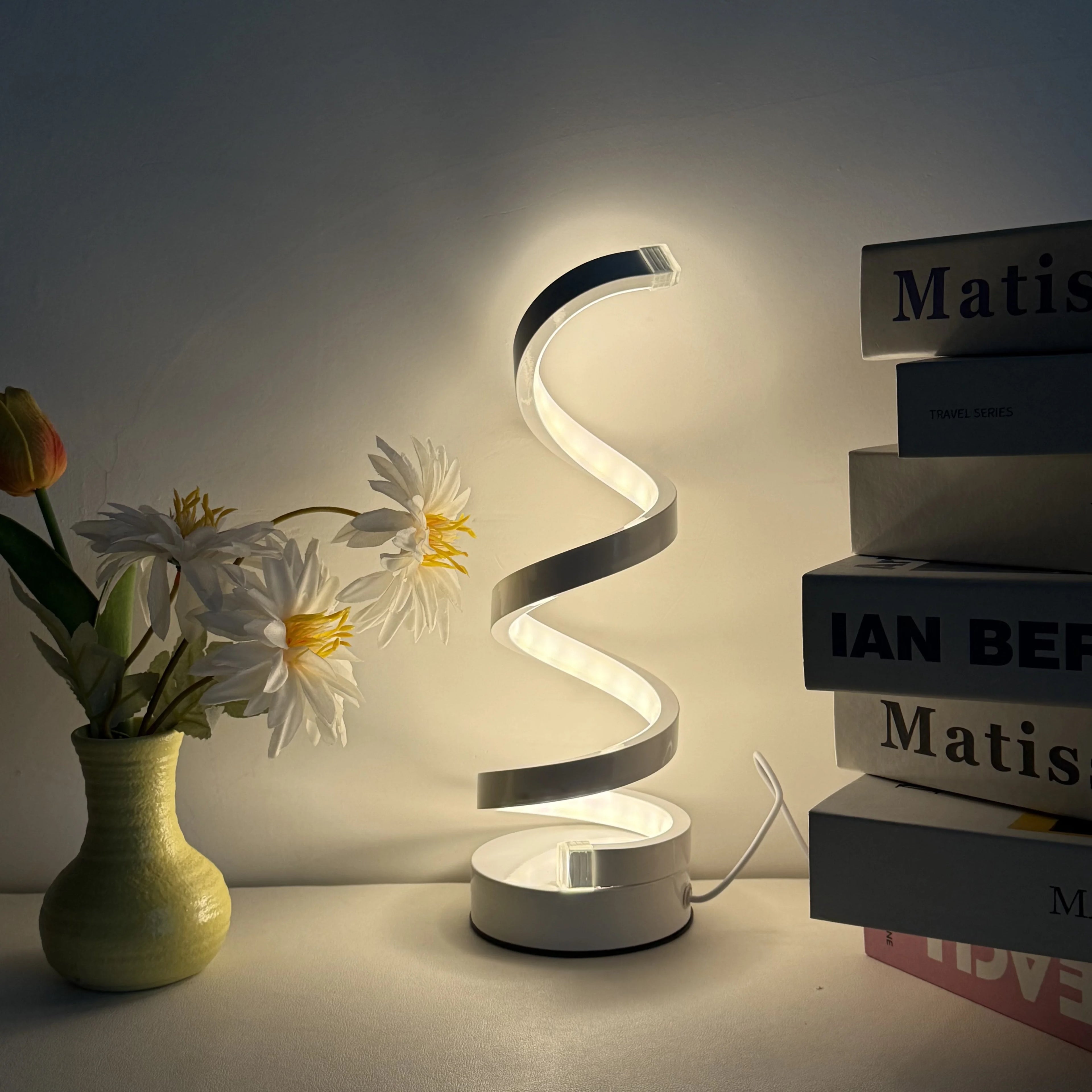 A modern, elegant white spiral desktop lamp, powered by USB with three-color dimming, suitable for various types of rooms.